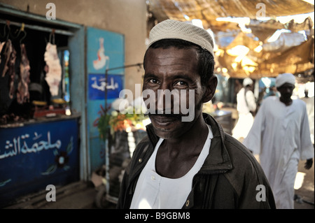 Uomo sudanese nella parte anteriore del negozio, di stallo nella città di debba, Sudan settentrionale, Africa Foto Stock