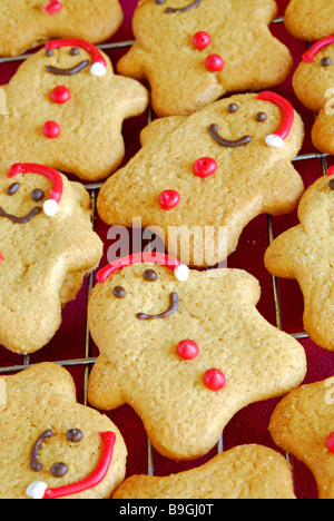 Un sacco di piccoli gingerbread Santas raffreddamento su un filo raffreddamento per rack. Foto Stock