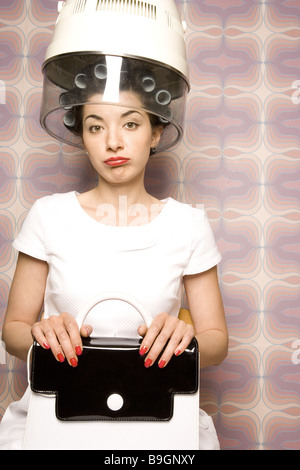 Stato fastidioso salone di coiffeur donna bigodini essiccatore semi-portrait 20-30 anni 70er anni bellezza donna parrucchiere-visita Foto Stock