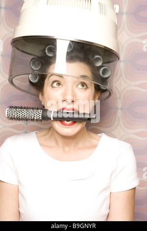 Salone di coiffeur donna bigodini bocca essiccatore round-spazzola ritratto 20-30 anni 70er anni spazzola di bellezza vanità donna Foto Stock