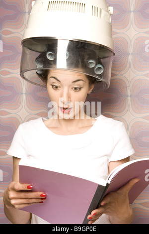 Salone di coiffeur donna bigodini essiccatore illustrato stupisce lettura semi-portrait 20-30 anni 70er anni prestige vanity di bellezza Foto Stock