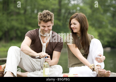 Il lago di Ponte di coppia innamorata seduta picnic Foto Stock