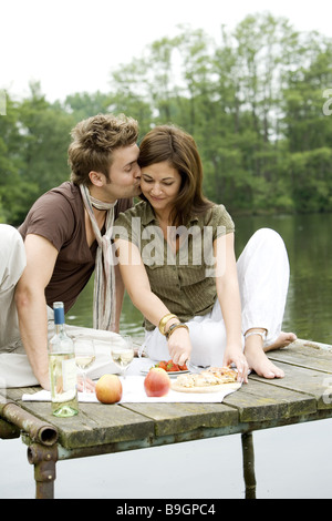 Il lago di Ponte di coppia innamorata seduta poggia picnic Bagno-bridge snack Relax Tempo libero Tempo libero frutti insieme Foto Stock