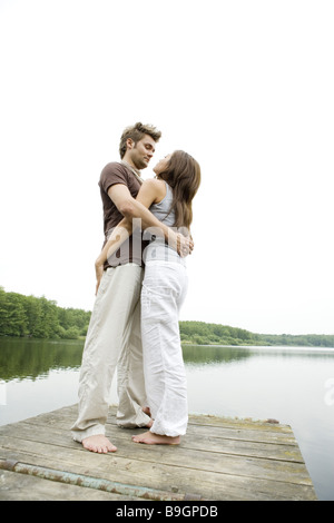 Il lago di Ponte di coppia innamorata sorge abbracciare il contatto visivo si appoggia bath-ponte lo sguardo a piedi nudi-contatto Relax Tempo libero Foto Stock