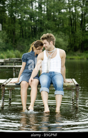 Il lago di coppia seduta ponte piedi acqua splash felice 20-30 anni il raffreddamento al di fuori del bagno-Ponte Scalzi ristoro relax Foto Stock