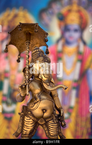 Statua di metallo del dio indiano Ganesh holding ombrello con colorato sfondo indiano. Ganesh è anche noto come Ganapati & Vinayaka Foto Stock