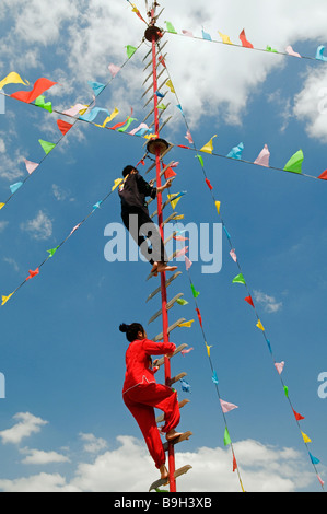 Cina Pechino le minoranze etniche Park acrobati salendo una scala di lame Foto Stock