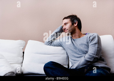 Uomo seduto sul lettino Foto Stock