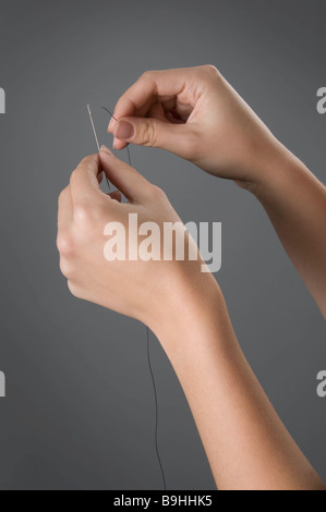 Mani femminili ago passafilo Foto Stock