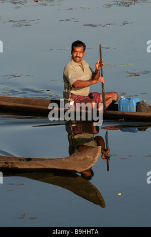 Uomo indiano in canoe di legno in Kerala backwaters Foto Stock