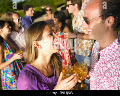 Le persone aventi un drink al tramonto Foto Stock