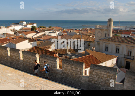 Due turisti camminando lungo la merlatura, Saintes Maries de la Mer, Camargue, Francia Foto Stock