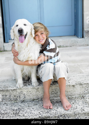 Ragazzo con cane sul gradino della porta Foto Stock