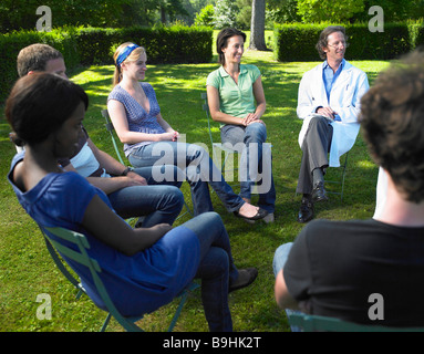 Circolo di persone seduti su sedie Foto Stock