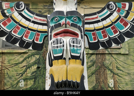 Il totem pole di Cowichan indiani, close-up, di fronte a una casa dipinta di parete, Duncan, Isola di Vancouver, Canada, America del Nord Foto Stock