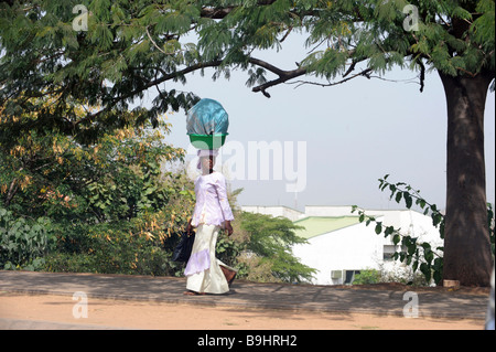 Donna che trasportano merci sul suo capo ad Abuja, Nigeria, Africa Foto Stock