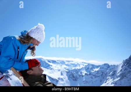 Donna con uomo seduto nella sedia a sdraio Foto Stock