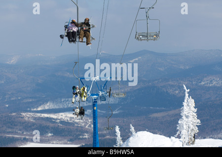 Gli sciatori su un impianto di risalita fino al monte Foto Stock