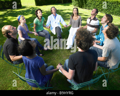 Circolo di persone in riabilitazione, tenendo le mani Foto Stock