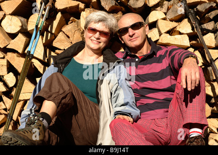 Il vecchio in età matura rilassarsi di fronte ad una pila di legno Foto Stock