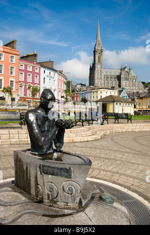 La statua del navigatore e Cobh waterfront con San Colman's Cathedral in background in una giornata di sole, County Cork, Irlanda Foto Stock