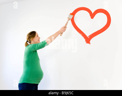 Donna incinta vivaio di verniciatura Foto Stock