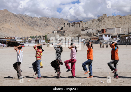Gli alunni Ladakhi la formazione del marzo dopo una scuola indiana di tradizione nella parte anteriore del Leh Palace, Ladakh India del Nord, Himalaya, Asia Foto Stock