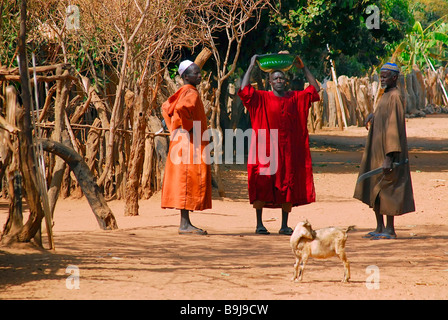 Tre uomini della tribù Jolla che conversano in una strada di villaggio a Tunami Tenda, Gambia, Africa Foto Stock