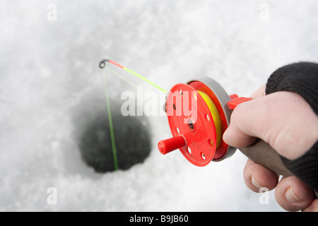 Canna da pesca del ghiaccio rosso a portata di mano , Finlandia Foto Stock