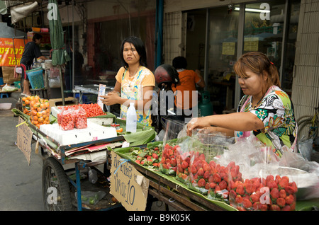 Due Signore thailandesi che vendono frutta fresca presso le bancarelle di strada a Bangkok Thailandia Foto Stock