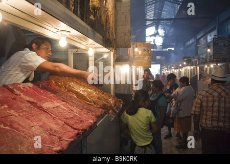 Un uomo effettua chiamate agli acquirenti in un mercato di carne nella città di Oaxaca, Oaxaca, Messico. Foto Stock