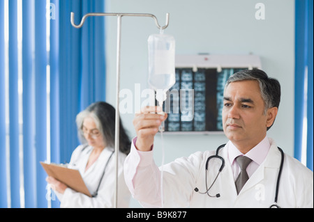 Controllo medico di una goccia di soluzione salina Foto Stock