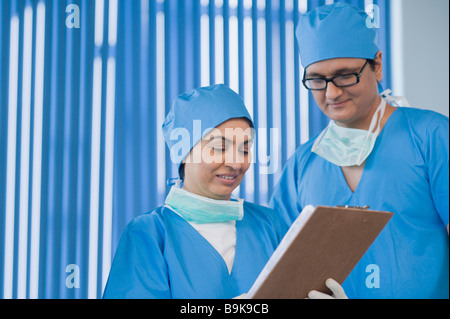 Due chirurghi discutendo record medici Foto Stock