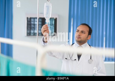 Controllo medico di una goccia di soluzione salina Foto Stock