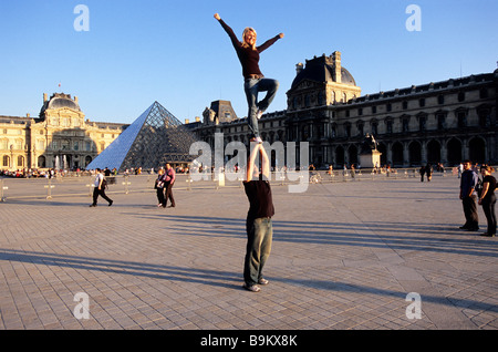 Francia, Parigi, acrobati i turisti di fronte al Museo del Louvre Foto Stock