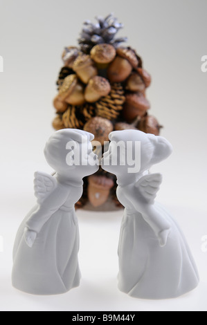 Porcellana Bianca un ragazzo e una ragazza baciare gli angeli nella parte anteriore di un dado e acorn albero di Natale su sfondo bianco Foto Stock