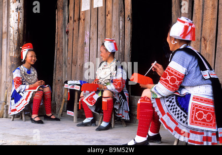 Cina, Guizhou, donne di Gejia gruppo etnico che indossa un copricapo in forma shako coperto con fili di lana, tenere premuto Foto Stock