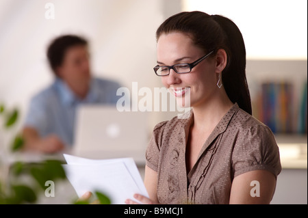 Giovane donna in ufficio Foto Stock