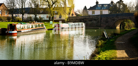 Narrowboats ormeggiate lungo il Kennet and Avon Canal a Hungerford Wharf Berkshire England Regno Unito, Hungerford Bridge in background Foto Stock