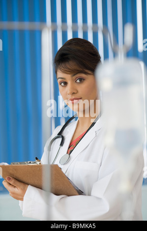 Medico donna la scrittura su una clipboard Foto Stock