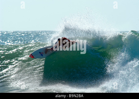 Diritto hander. Surfista maschio cavalca la cresta dell'onda. Foto Stock