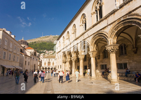 Turisti e visitatori di passeggiare al di fuori del Palazzo dei Rettori nelle mura della città di Dubrovnik in estate sole costa dalmata croato Foto Stock