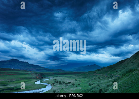 Un moody sera cielo sopra la valle di Tugela con le montagne Drakensberg oltre, KwaZulu Natal, Sud Africa Foto Stock