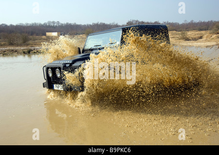 Un Land Rover Defender aziona attraverso un diluvio Foto Stock