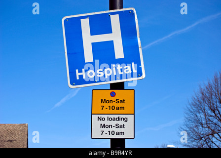 British blu e bianco segno dell'ospedale e i segni che mostra le restrizioni per il parcheggio Foto Stock