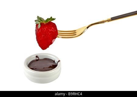 Fragola singolo su una forcella dorata con cioccolato di immersione Foto Stock