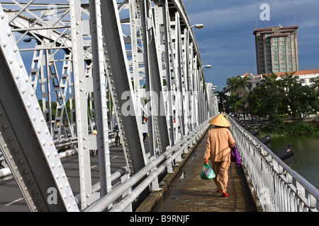 Scena di strada. Donna vietnamita con il tradizionale cappello conico camminando sul ponte in tinta. Il Vietnam Foto Stock
