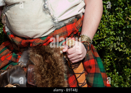 Highlander scozzese. L'uomo indossando il tradizionale kilt & holding pugnale, sgian dhu dirk a Hawick festival Reivers, Scottish Borders, Hawick Scozia, Regno Unito Foto Stock