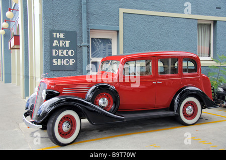 Vintage auto rossa al di fuori di art deco shop napier, Nuova Zelanda Foto Stock