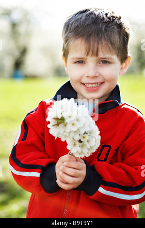 Little Boy holding mazzetto di fiori ciliegio Foto Stock
